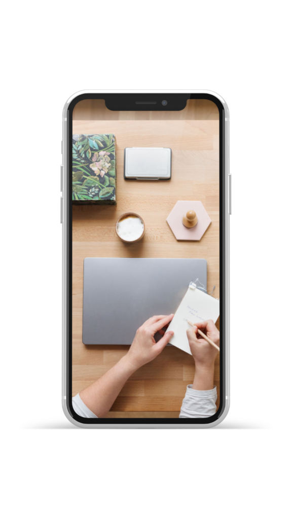 Schreibtisch mit Laptop, Notizblock und Wasserglas