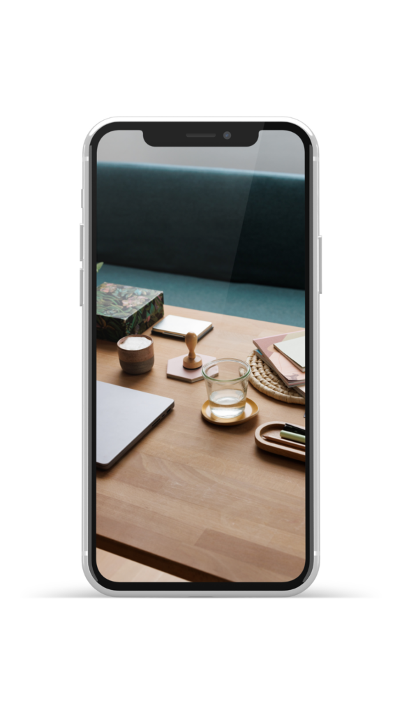 Schreibtisch mit Laptop, Notizblock und Wasserglas