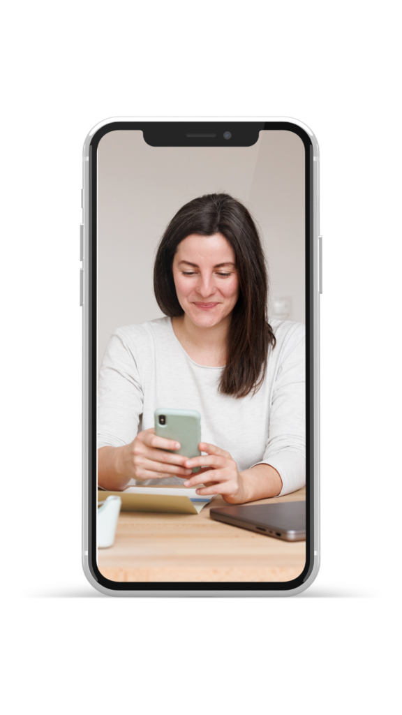 Frau mit Handy am Schreibtisch